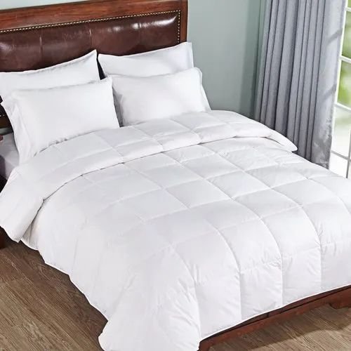 White quilted comforter on a wooden-framed bed