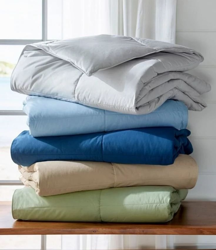 Coloured lightweight comforters folded in a stack