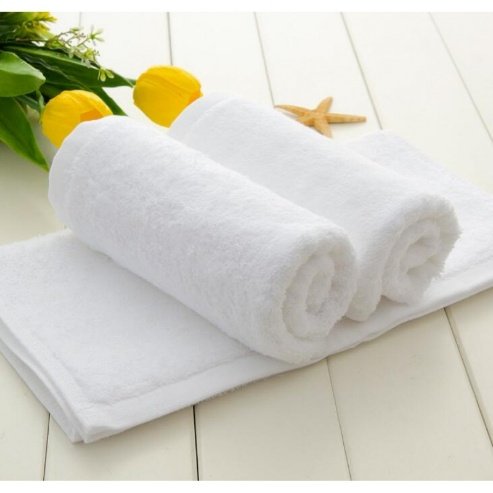 Two rolled white hotel bath towels with tulips